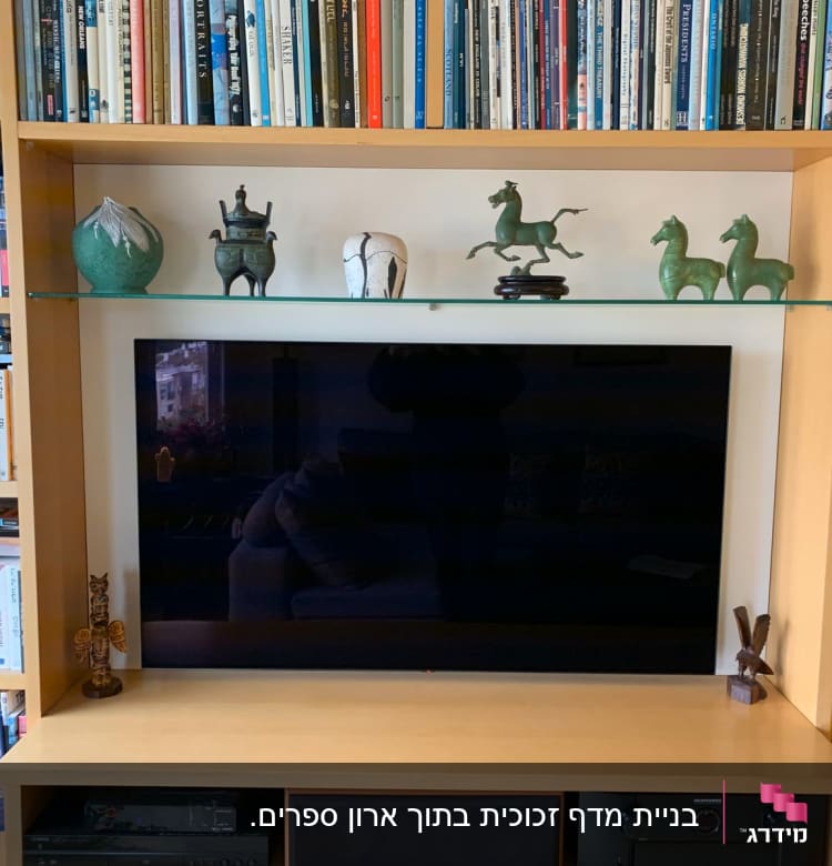 מדף עץ עם פסלים וספרים